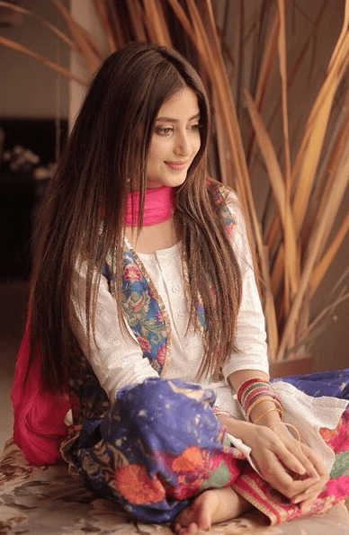 Sajal Aly might be one of the most popular actresses, but she is the one we seldom see if she isn’t acting or is on our screens. The actress takes her fair time updating Instagram or posting anything that can give us a glimpse of what she is up to these days. It is due to designers or makeup artists most of the time that we get to see her work. But this time, Aly herself has posted pictures from a new photoshoot and she gives the perfect representation of the old-era vibes in the beautiful dresses and makeup she has adorned. Sajal Aly’s New Photo Shoot The makeup artist Zamin Raza around a week ago posted the picture of him and Sajal where we can see her all glammed up posing for a mirror selfie with him. Soon after, pictures from the shoot for a designer followed, and we get to see two different but equally gorgeous looks of her. Here is the picture he posted on his Instagram account: Pictures From The Shoot The shoot was for the Eastern collection of Asma Abbas designs, and who better than Sajal to rock those looks? The first look had a minimal makeup with her beautiful hair all straightened. The dress is a Shabnam Koti with a Naghma shalwar. Here are the pictures of the shoot in this dress: Do you know a fun fact? Just as the pictures were uploaded on Sajal’s Instagram account fans flooded the designer’s DM, which made this color run out within a few hours only. It still hasn’t been restocked. Talk about people going gaga over their favorite celeb’s choice. Another look from the shoot is more of a conventional, classic 90s era vibe, which Sajal is famous for. Though the complete dress pictures aren’t released yet, here are the two pictures shared on the social media accounts: If you can’t take your eyes off of these beautiful pictures, don’t worry, we can’t either. Who Was The Shoot For? The shoot was for the upcoming designer making her way through the fashion square, Asma Abbas Designs. The photography was done by Rehan Mithani Photography whereas the hair and makeup were by Zamin Raza. What Is Sajal Doing These Days? Since we haven’t seen her on the screen for quite some time, everyone has been pondering over what she is up to these days and what projects are under her belt after the grand wedding. Well, that’s still under the wraps because the star hasn’t revealed anything about her upcoming projects. Just like you, we will also wait to see what amazing things she has under her belt for us. 