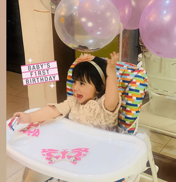 The most beautiful and well-known former actress Aisha Khan has finally revealed her daughter's face on social media. We have been observing that Aisha was a little bit conscious about the public appearance of her daughter Mahnoor, however, she has finally unveiled the adorable baby on her first birthday. Here we have got a collection of pictures from Mahnoor's birthday. Aisha Khan Unveils Mahnoor's Face on First Birthday Aisha and his husband Uqbah Malik have arranged a small yet colorful birthday party for their daughter Mahnoor. The couple looks quite happy as their daughter has filled up their lives with colors. They have celebrated this birthday according to the Islamic calendar date of birth. Check out these wonderful clicks of Mahnoor with her parents and grandparents! Aisha Khan penned a heartwarming note for her daughter with the pictures she posted on Instagram. Here is what she expressed: "HAPPY 1 ST (ACCORDING TO THE ISLAMIC CALENDAR) BIRTHDAY TO THE 🍎 OF MY EYE.... THE CENTER OF MY UNIVERSE.... THE LOVE OF MY LIFE....MY DARLING BABY GIRL WITH A SMILE SO BRIGHT THAT IT'S HARD TO SEE ANYTHING ELSE. ON THIS BLESSED DAY ALLAH BLESSED UQBAH AND I WITH THE MOST PRECIOUS GIFT.... ALL WORDS FALL SHORT IN EXPRESSING HOW GRATEFUL WE ARE....GRATEFUL THAT YOU’RE HEALTHY...GRATEFUL THAT YOU ARE SURROUNDED BY PEOPLE WHO ABSOLUTELY ADORE YOU...GRATEFUL THAT YOU ALWAYS HAVE THAT BILLION-DOLLAR SMILE ON YOUR FACE..." She further added: "...AND ABOVE ALL GRATEFUL THAT ALLAH CHOSE YOU TO BE OURS. THERE ISN'T A THING IN THE WORLD WE WOULDN'T DO TO SEE YOU GROW INTO A KIND STRONG BEAUTIFUL HUMAN BEING. MAY YOU SHINE THE BRIGHTEST MY LITTLE STAR.... AND GET THE BEST OF EVERYTHING IN THIS WORLD AND THE HEREAFTER. ALTHOUGH THIS WASN'T WHAT WE HAD PLANNED FOR HER FIRST BIRTHDAY, WE ARE SO GRATEFUL TO THE BEST NANA AND NANOO FOR PUTTING THIS LITTLE ARRANGEMENT TOGETHER AS A SURPRISE IN THESE STRANGE AND DIFFICULT TIMES.... 12 RABI UL AWAL- SO SO SPECIAL IT ALWAYS WAS AND WILL ALWAYS BE...💕💕💕" Some More Clicks of Baby Mahnoor! Here we have got some more clicks of baby Mahnoor when Aisha kept her face hidden. Take a look! We wish Mahnoor a very happy birthday according to the Islamic calendar and greetings to Aisha Khan and Uqbah Malik!